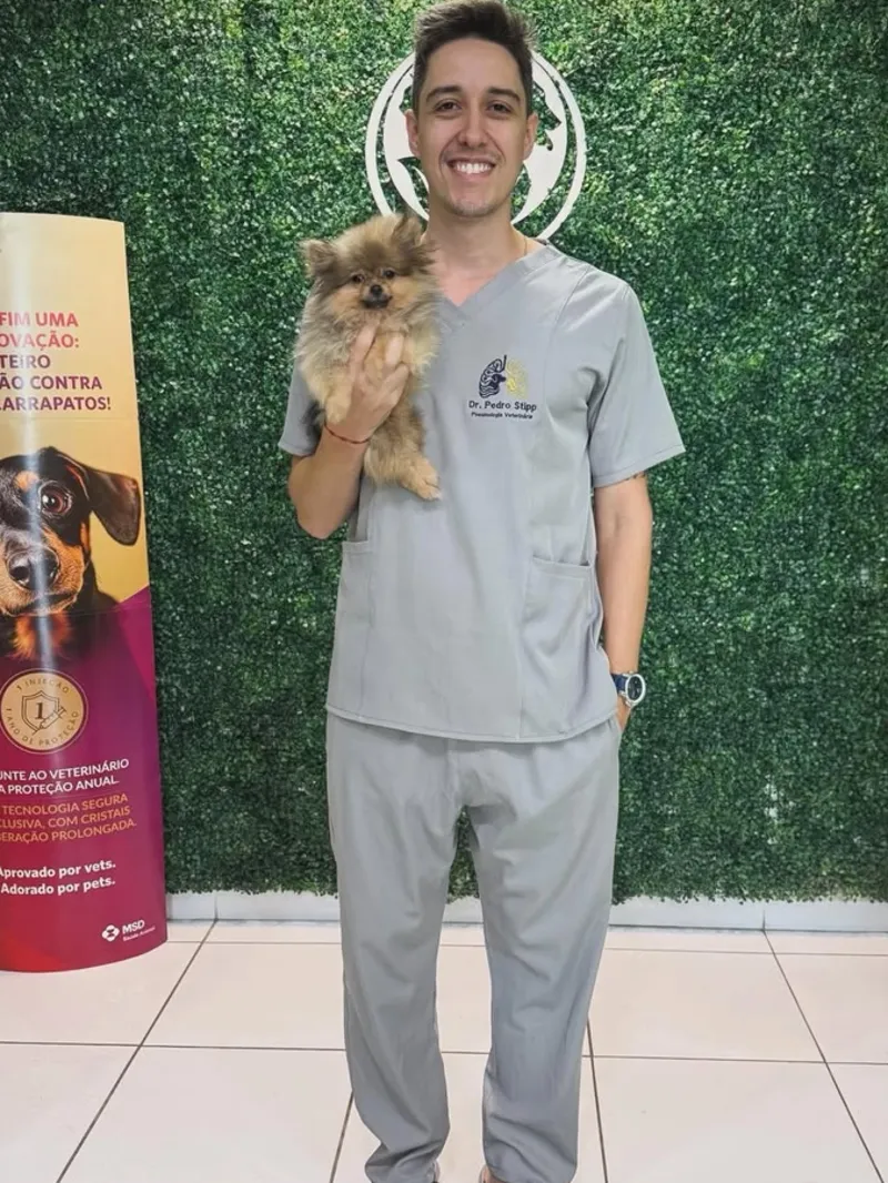 Dr. Pedro Stipp segurando o lulu-da-pomerânia Lyon no dia da vacina
