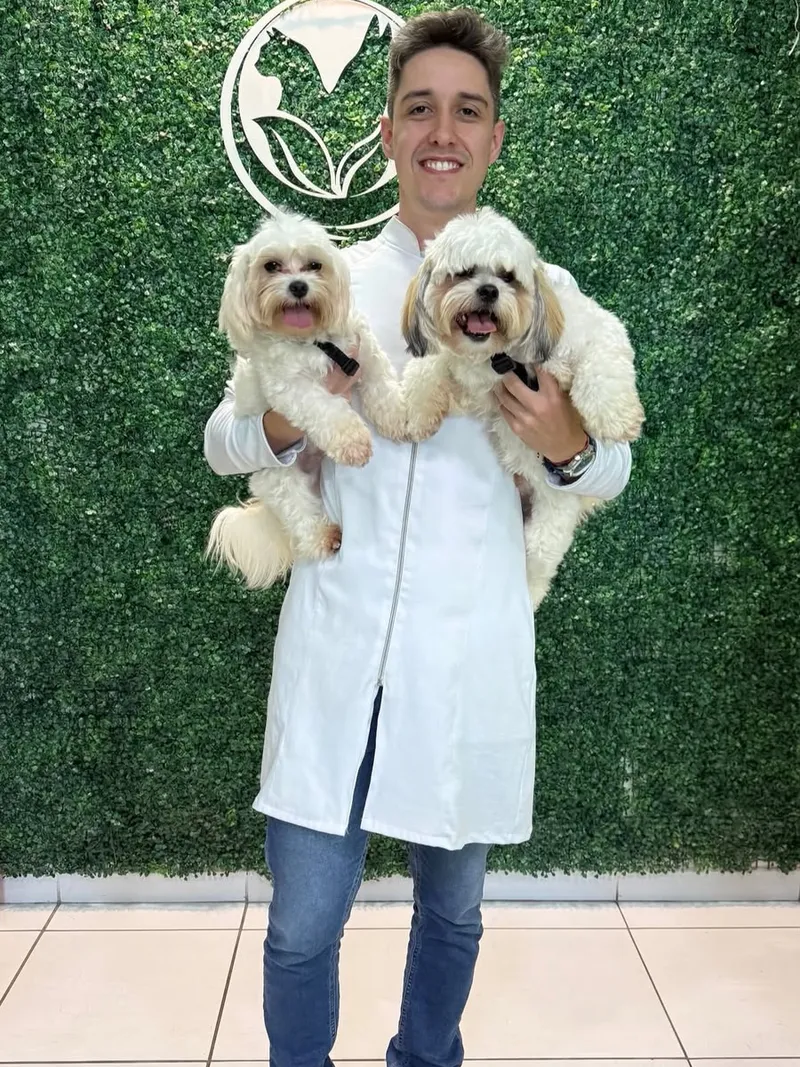Dr. Pedro Stipp segurando os cães Theo e Thor no dia da vacinação