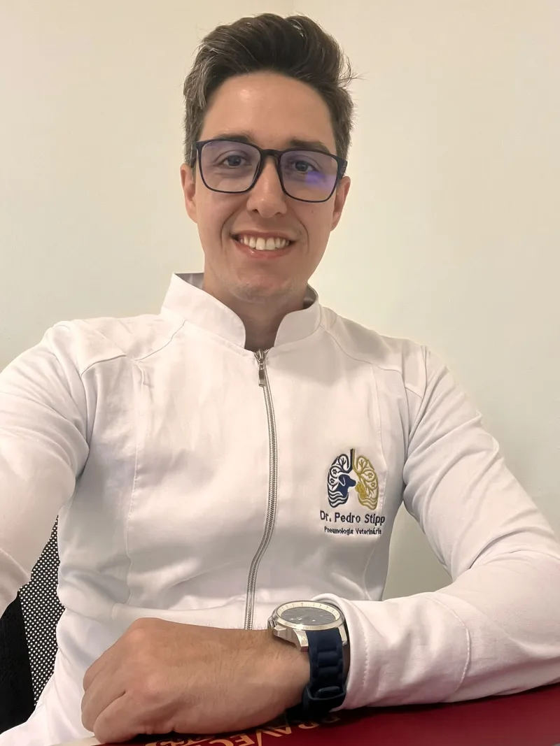 Dr. Pedro Stipp, médico veterinário, de jaleco com a logo do pulmão